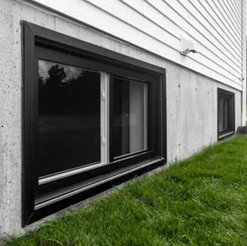 Vaillancourt Doors and Windows sliding windows in black PVC, one large on the first floor and one small in the basement.