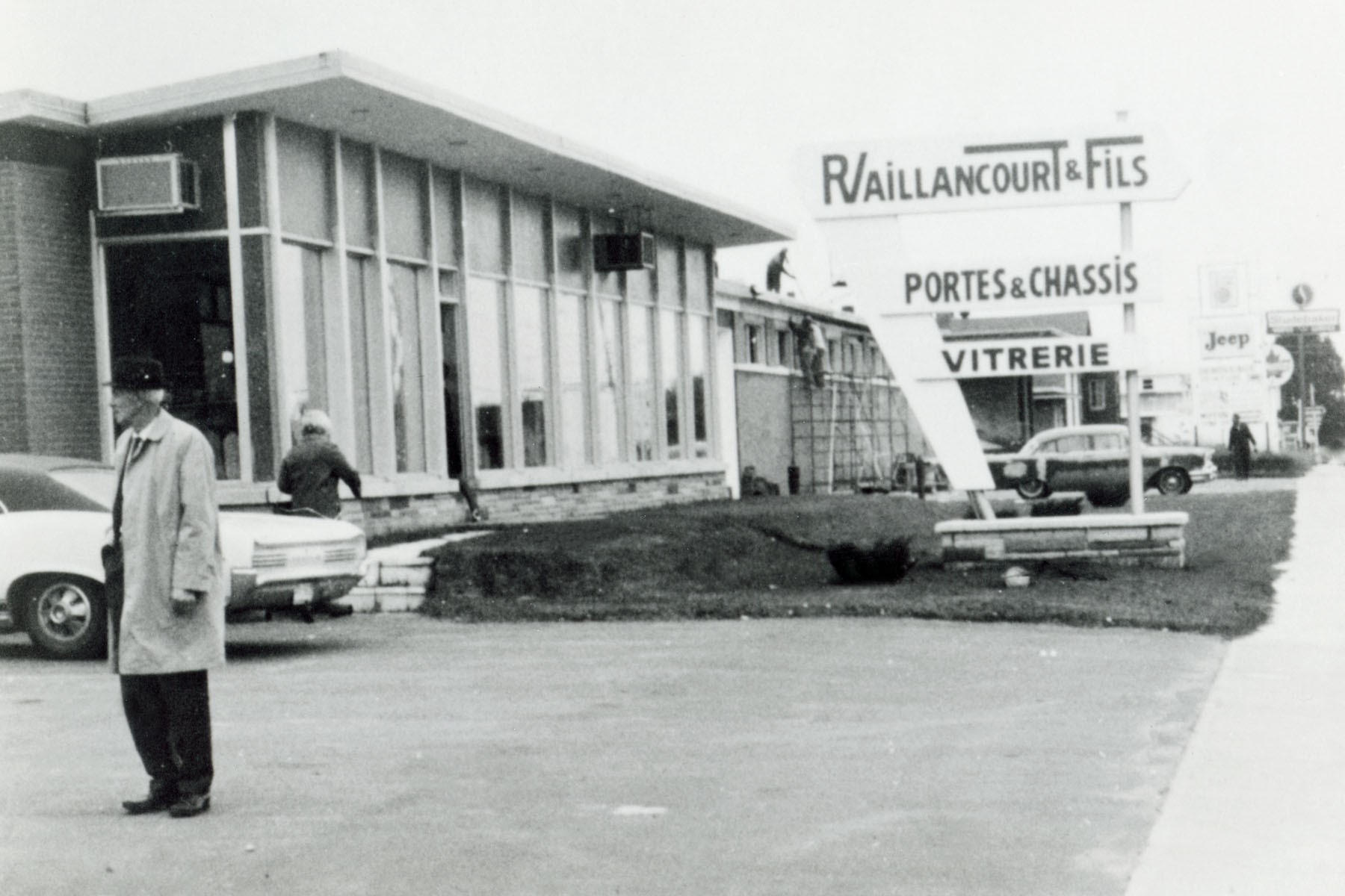 Raymond Vaillancourt se tient devant la première usine R Vaillancourt portes et châssis sur la rue Notre-Dame à Drummondville.