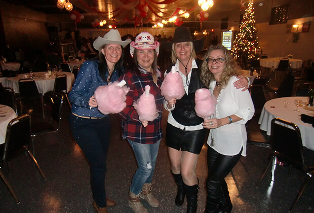 Employées de Vaillancourt Portes et Fenêtres habillées en vêtements country tiennent chacune une barbe à papa rose pour Noël
